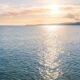 Sunlight reflecting on calm ocean water at sunset, cremation services in Apache Junction, AZ